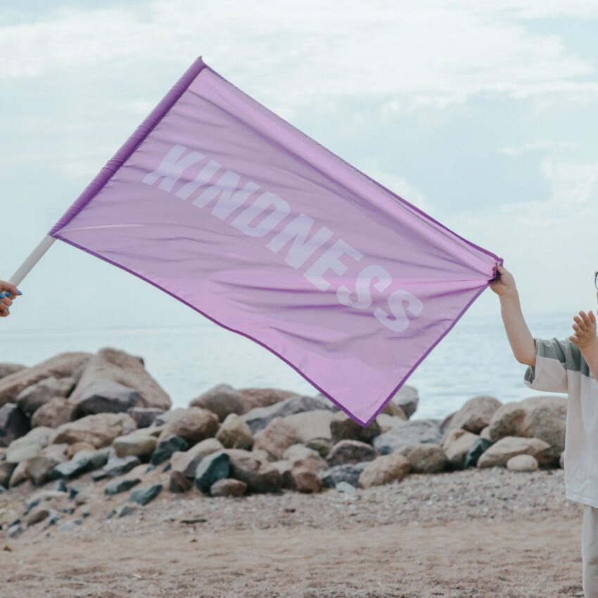 a young boy holding a purple flag