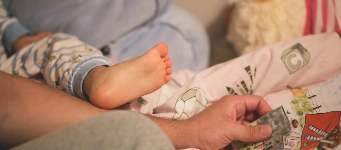 man holding magazine beside baby
